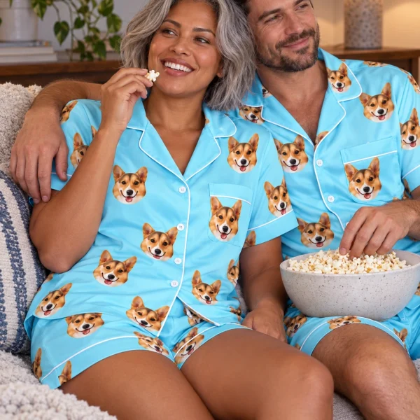 Woman and her partner in matching blue pajama set with tan-and-white corgi faces on light blue satin — MyDogPics