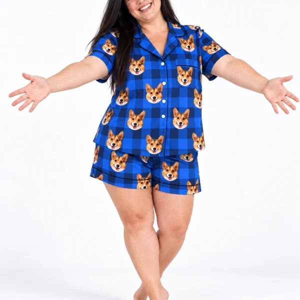 Woman wearing a blue pajama set covered in tan-and-white corgi faces on blue plaid satin — MyDogPics