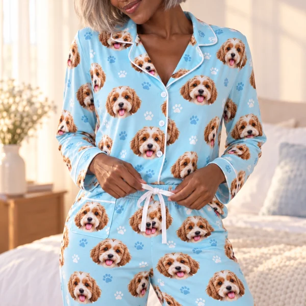 Close-up of the blue pajamas print: doodle puppy faces on light blue paw-print fabric with contrast piping — MyDogPics