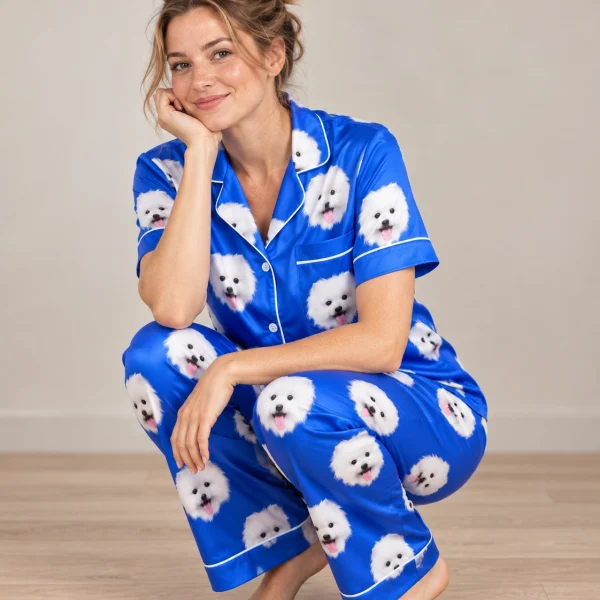 Woman posing in a button up pajama set, white Pomeranian faces on royal blue satin — MyDogPics
