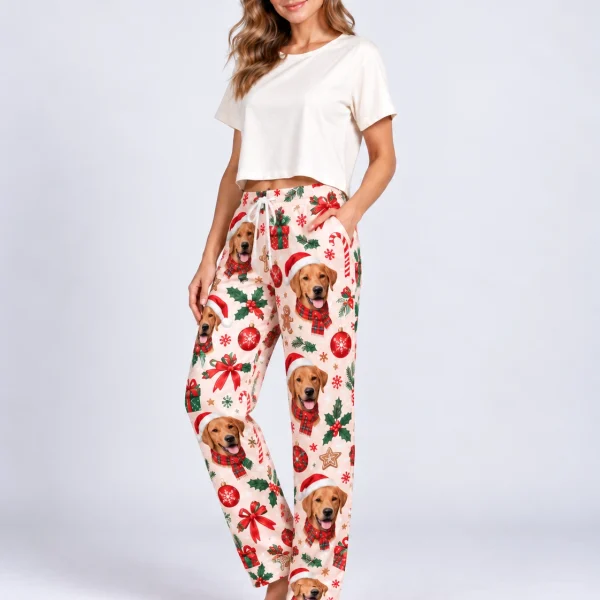 Woman posing in Christmas pajama pants with golden retriever faces in Santa hats — MyDogPics