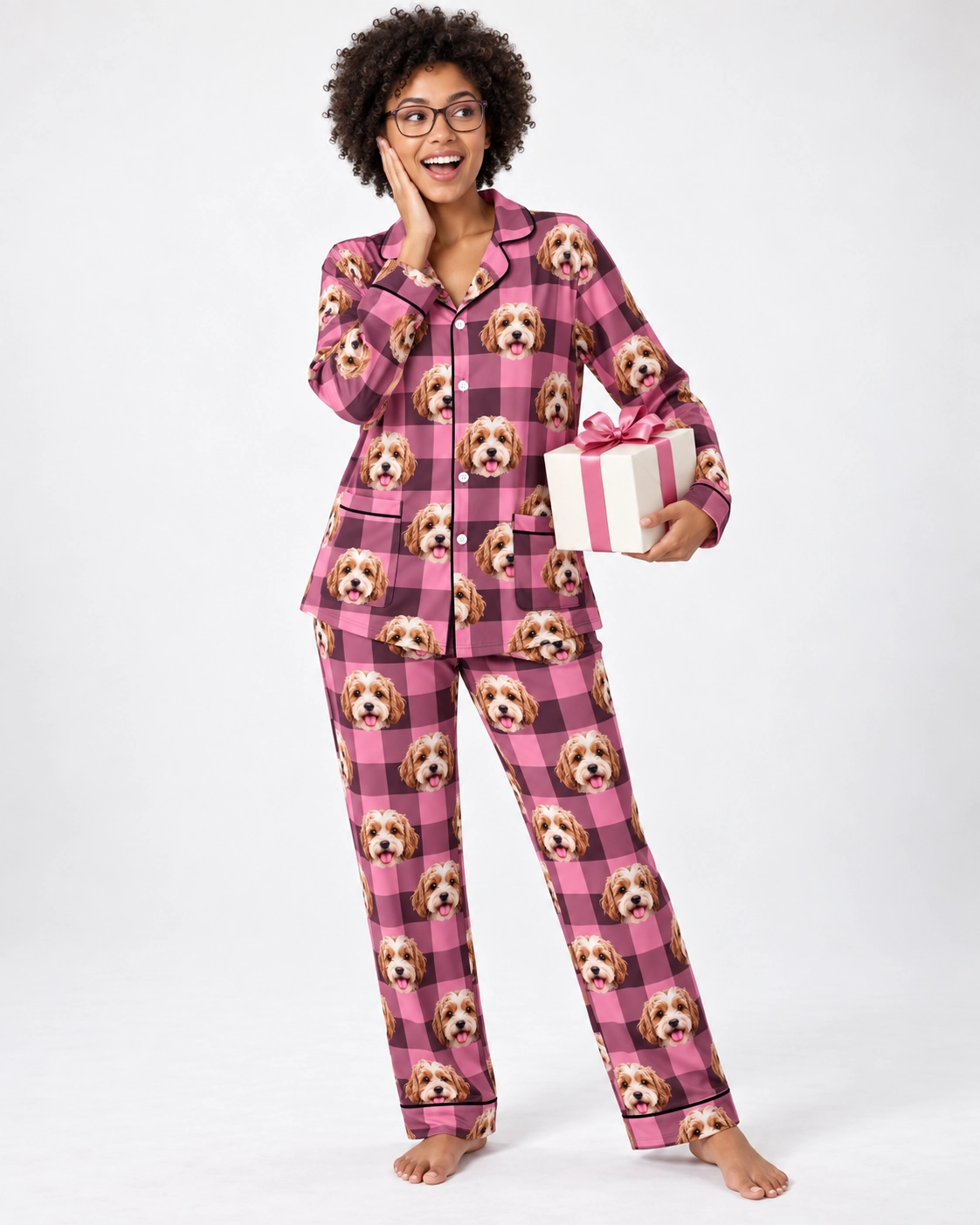 Classic Pajamas – Front View, Pink Plaid | MyDogPics Woman wearing classic pajamas covered in doodle puppy faces on pink plaid fabric with contrast piping — MyDogPics