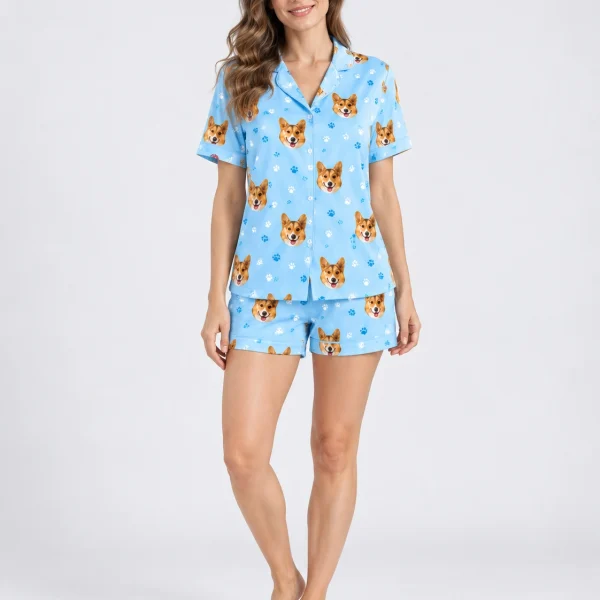 Woman wearing corgi pajamas covered in corgi faces on sky blue satin with paw prints — MyDogPics