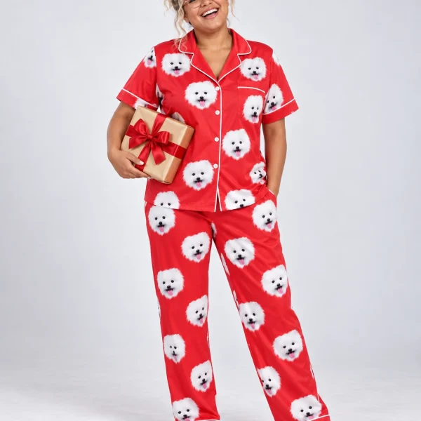 Woman wearing couples Christmas pajamas covered in white Pomeranian faces on red satin — MyDogPics