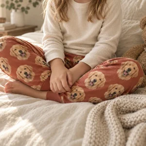 Custom kids pajamas worn on a bed with a teddy bear, golden retriever print — MyDogPics