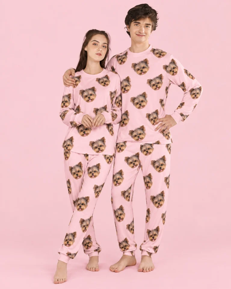 Couple wearing family matching pajamas covered in Yorkshire terrier faces on light pink fabric — MyDogPics