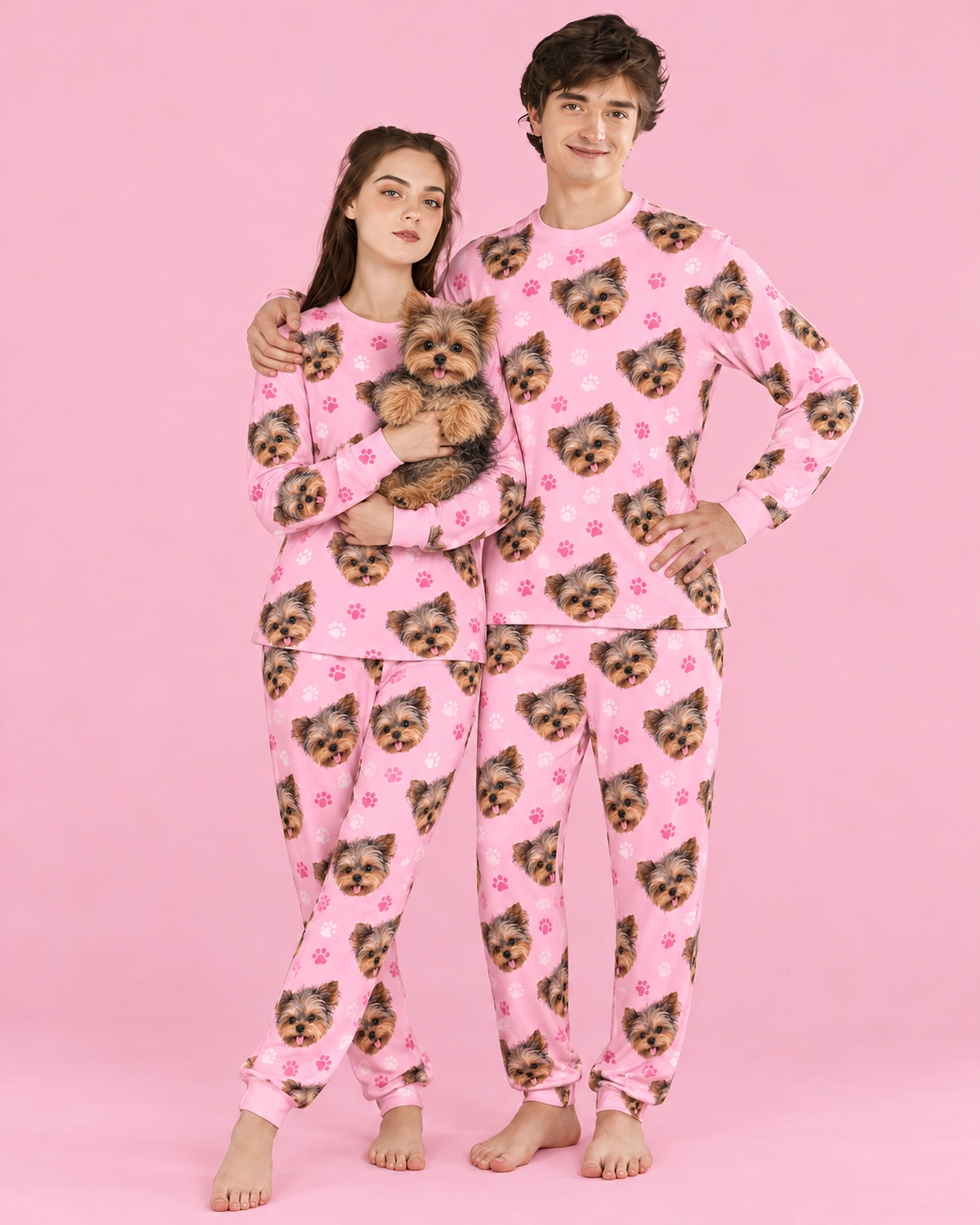Family Matching Pajamas – Holding Dog, Pink Paw-Print | MyDogPics Couple in family matching pajamas holding their Yorkshire terrier — MyDogPics