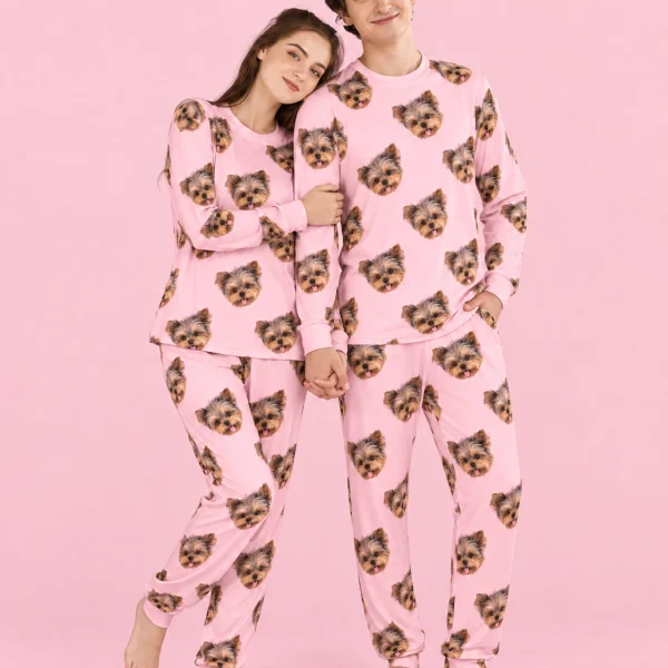Couple posing in family matching pajamas, Yorkshire terrier faces on light pink fabric — MyDogPics