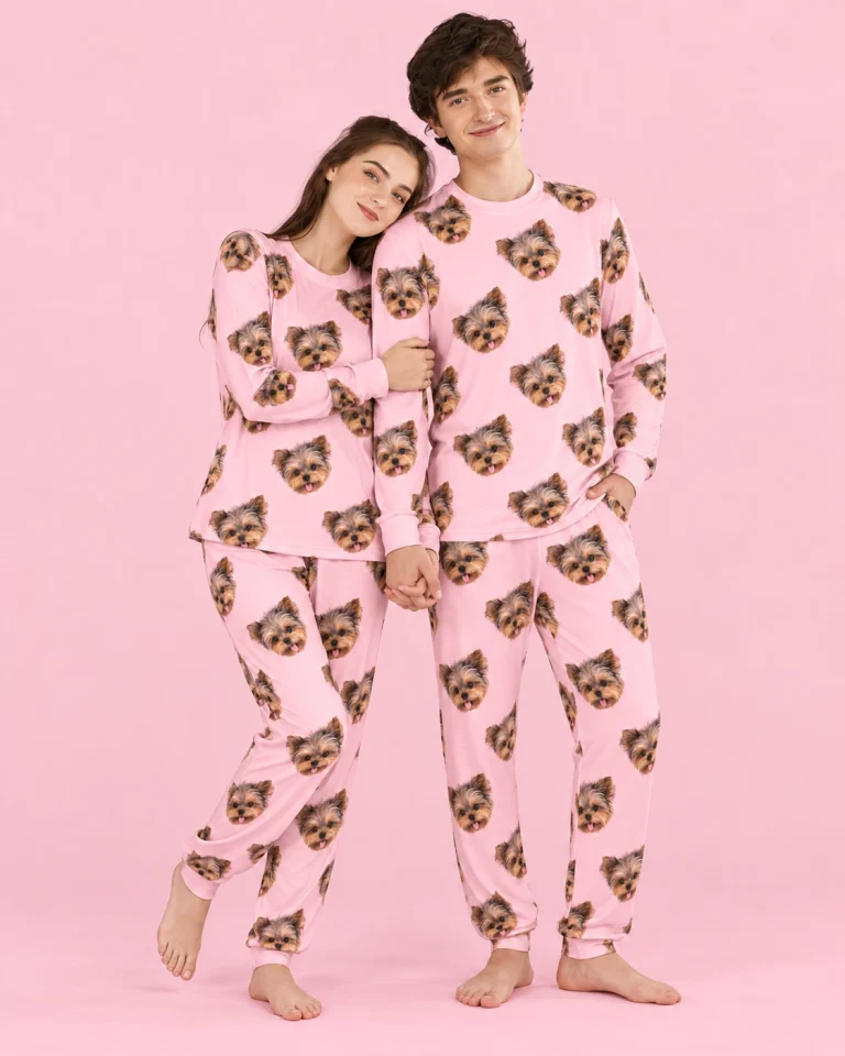 Couple posing in family matching pajamas, Yorkshire terrier faces on light pink fabric — MyDogPics