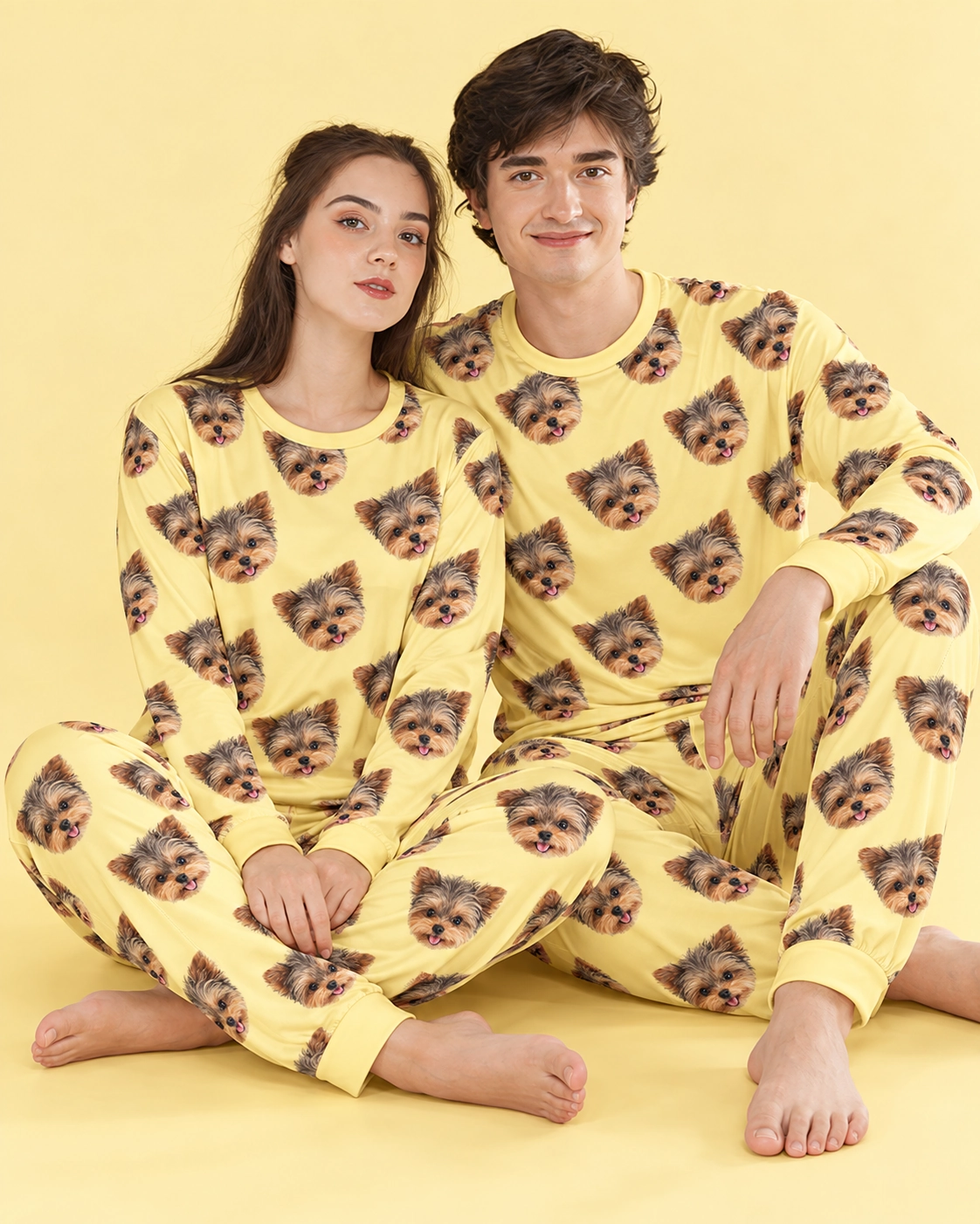 Family Matching Pajamas – Sitting, Yellow | MyDogPics Couple sitting in family matching pajamas covered in Yorkshire terrier faces — MyDogPics