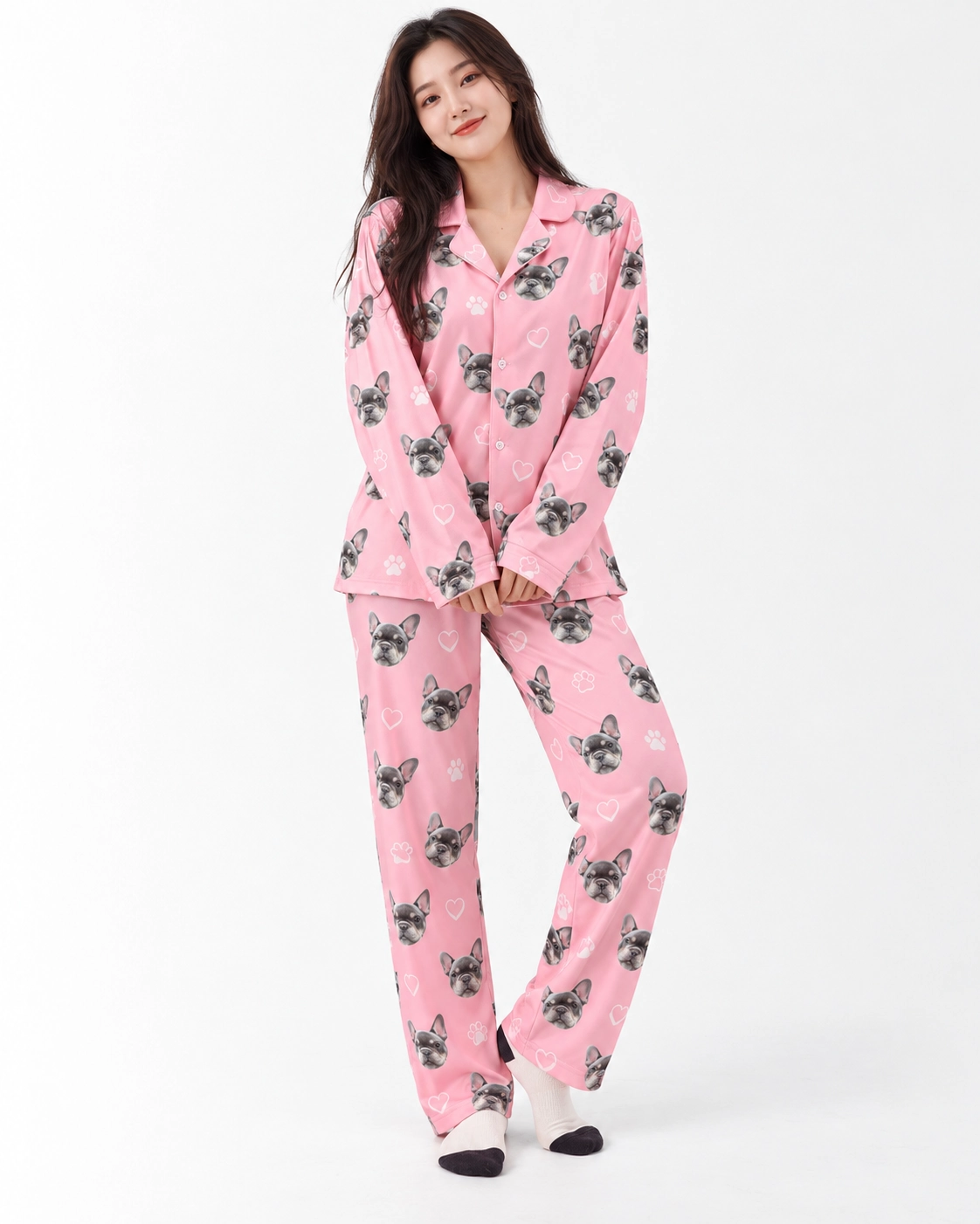 French Bulldog Pajamas – Front View | MyDogPics Woman wearing French bulldog pajamas covered in grey French bulldog faces on pink with white hearts and paws — MyDogPics