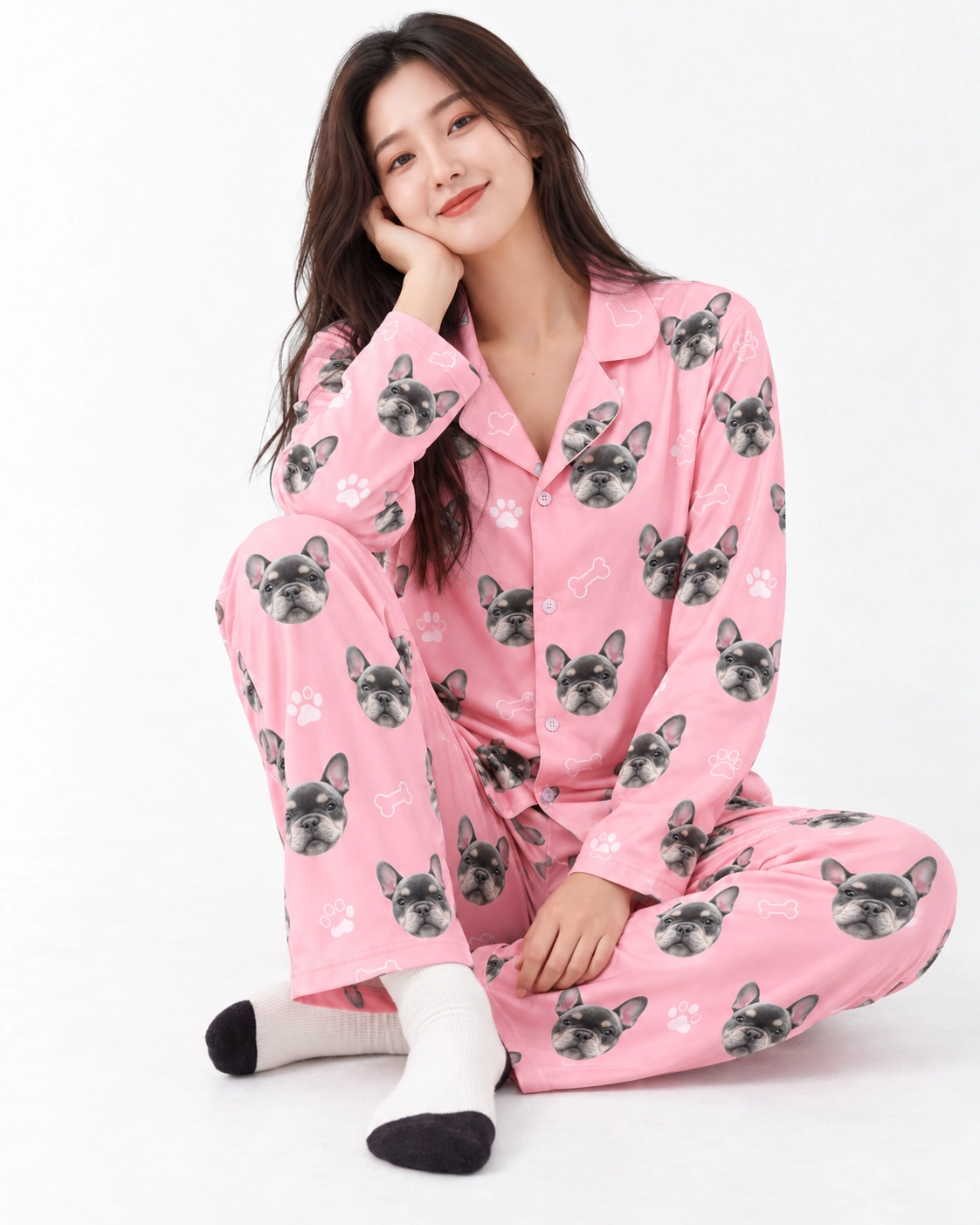 French Bulldog Pajamas – Sitting | MyDogPics Woman sitting in French bulldog pajamas covered in grey French bulldog faces — MyDogPics
