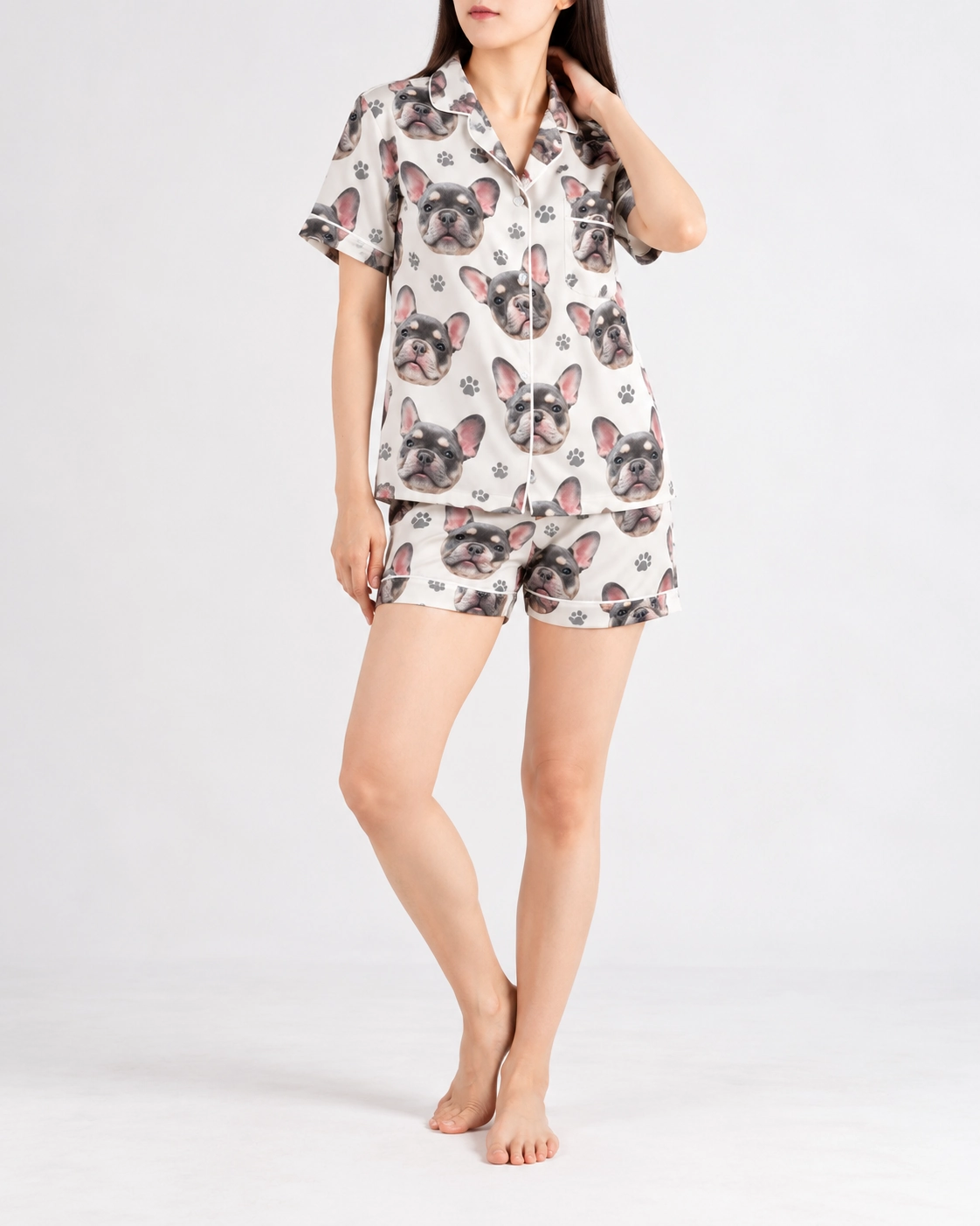 Frenchie Pajamas – Pose | MyDogPics Woman posing in frenchie pajamas, grey French bulldog faces on ivory satin with black paw prints — MyDogPics