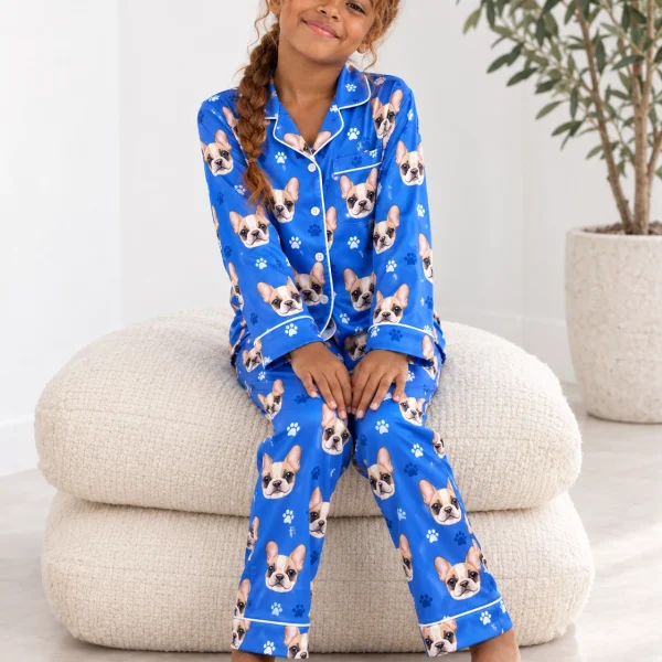 Girl sitting in a girls pajama sets covered in cream French bulldog faces — MyDogPics