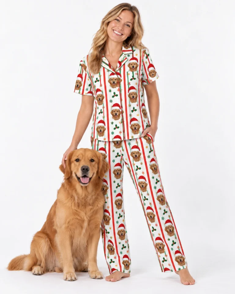 Woman in Christmas pajamas printed with golden retriever faces in Santa hats, standing beside her golden retriever