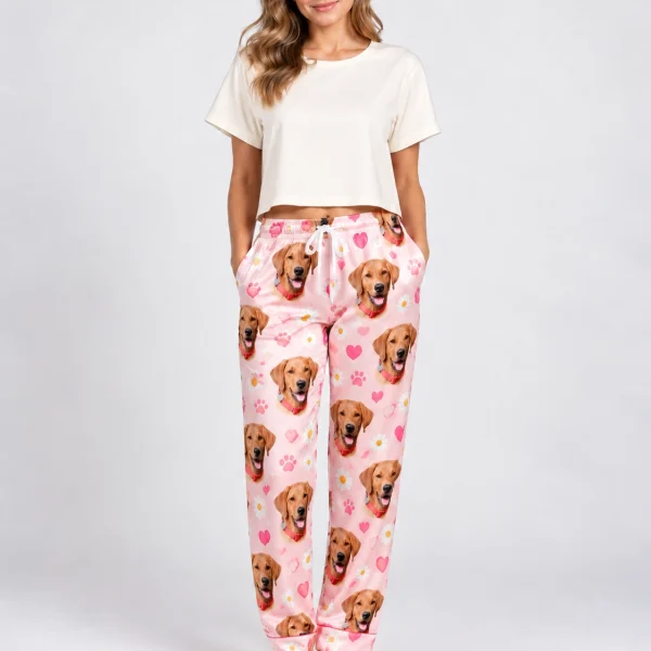 Woman wearing golden retriever pajama pants covered in golden retriever faces on a pink hearts and daisies print — MyDogPics