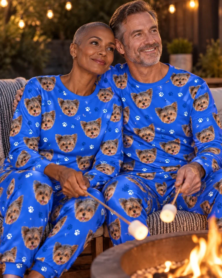 Woman and her partner in matching holiday pajamas with Yorkshire terrier faces on royal blue paw-print fabric — MyDogPics