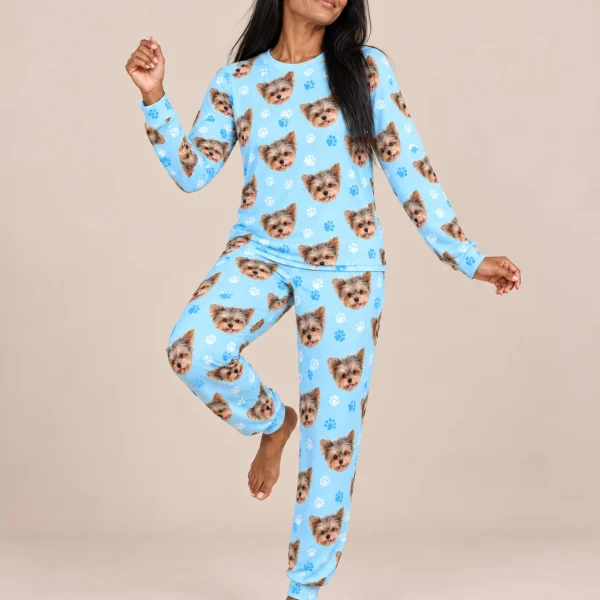 Woman posing in holiday pajamas, Yorkshire terrier faces on light blue paw-print fabric — MyDogPics