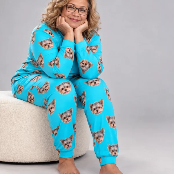 Woman sitting in holiday pajamas covered in Yorkshire terrier faces — MyDogPics