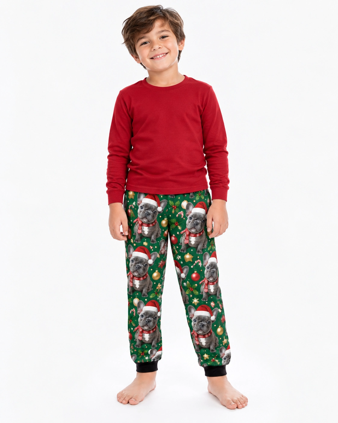 Kids Christmas Pajama Pants – Front View | MyDogPics Boy wearing kids Christmas pajama pants covered in French bulldog faces in Santa hats and scarves — MyDogPics