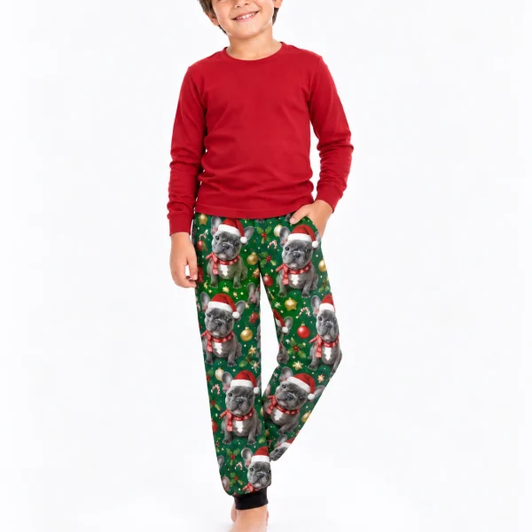 Boy posing in kids Christmas pajama pants with French bulldog faces in Santa hats and scarves — MyDogPics