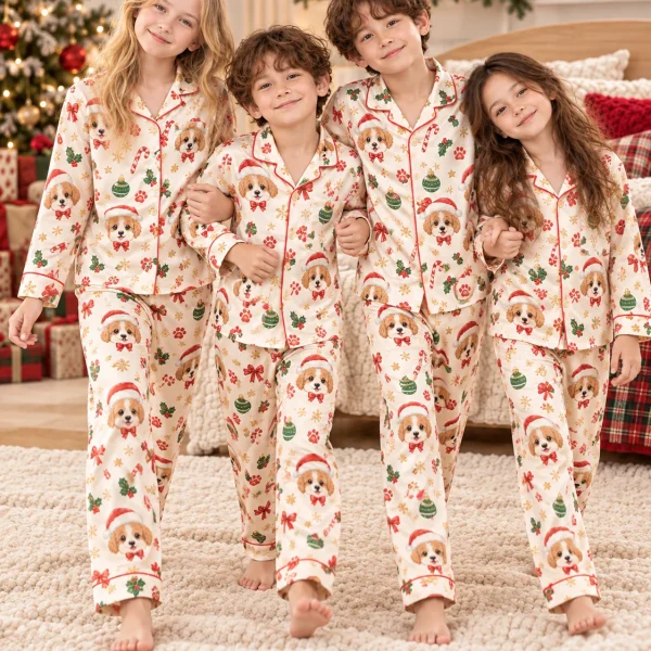 Kids in matching kids Christmas pajamas with Cavalier King Charles spaniel faces in Santa hats — MyDogPics