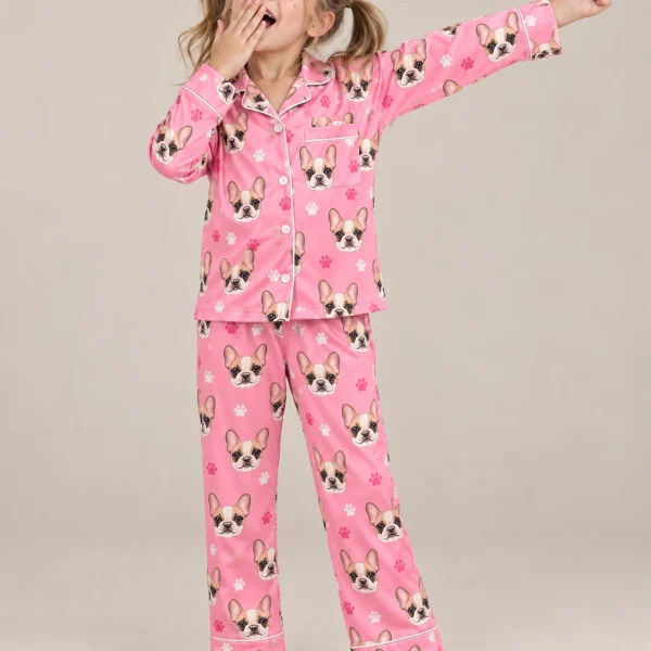 Girl posing in kids plaid pajamas, cream French bulldog faces on pink paw-print satin — MyDogPics