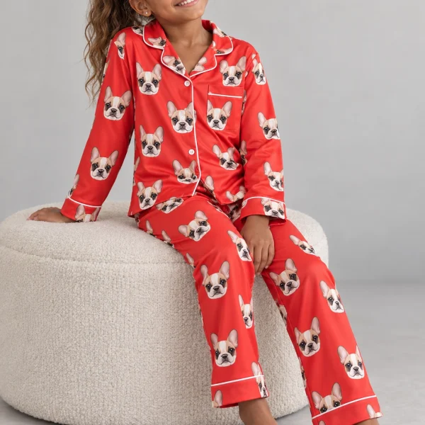 Girl sitting in kids plaid pajamas covered in cream French bulldog faces — MyDogPics