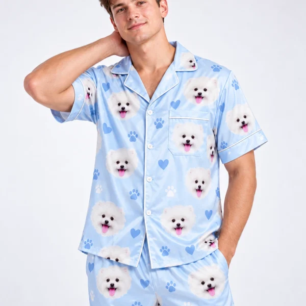 Man posing in matching couple pajamas, white Pomeranian faces on light blue satin with hearts and paw prints — MyDogPics