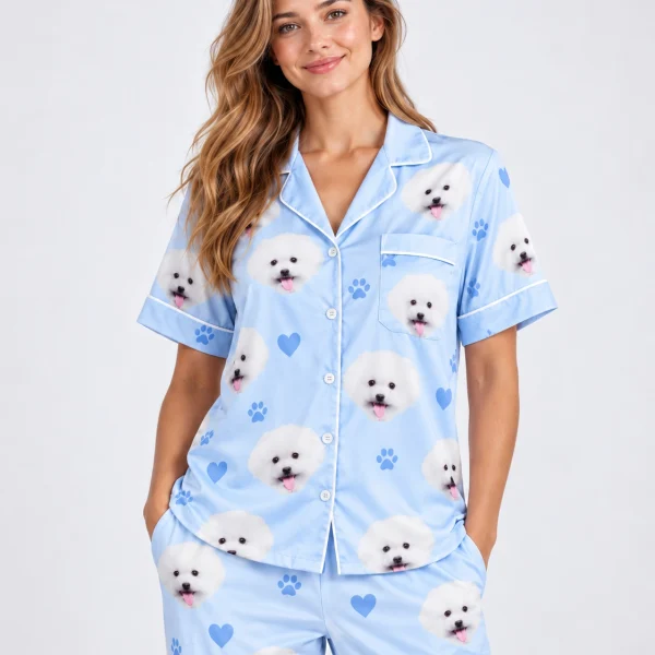 Woman posing in matching couple pajamas, white Pomeranian faces on light blue satin with hearts and paw prints — MyDogPics