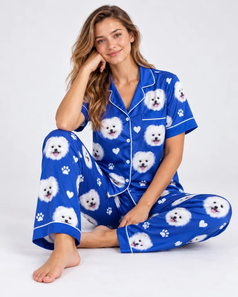 Woman sitting in matching couple pajamas covered in white Pomeranian faces — MyDogPics