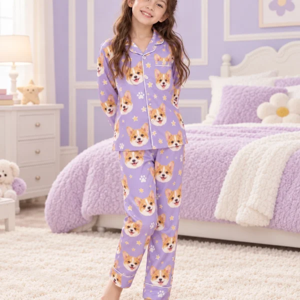 Child wearing matching kids pajamas covered in corgi faces on lavender satin with paw prints — MyDogPics