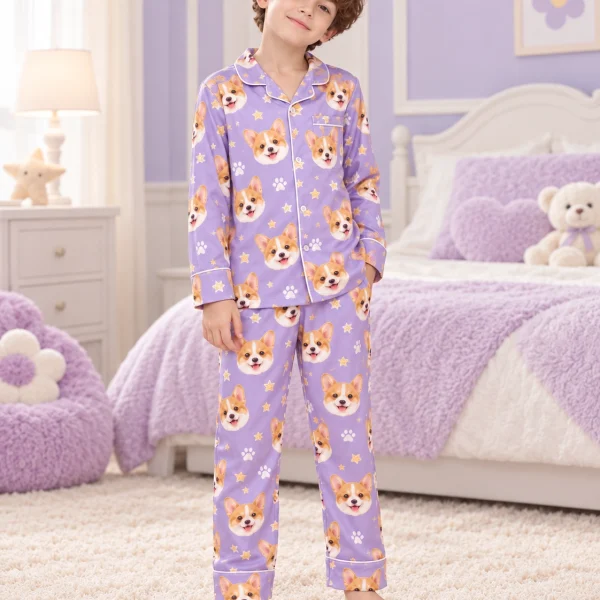Child wearing matching kids pajamas covered in corgi faces on lavender satin with paw prints — MyDogPics
