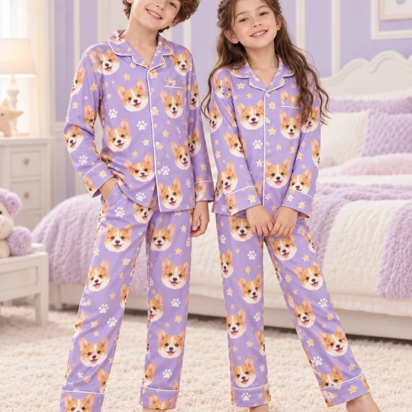 Two kids in matching kids pajamas with corgi faces on lavender satin with paw prints — MyDogPics