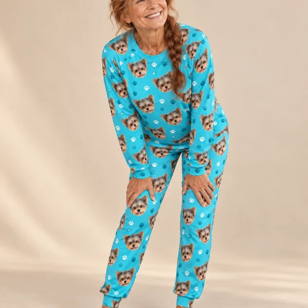 Woman wearing matching pajamas covered in Yorkshire terrier faces on teal paw-print fabric — MyDogPics