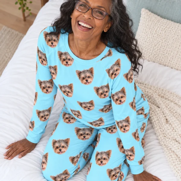 Woman sitting in matching pajamas covered in Yorkshire terrier faces — MyDogPics