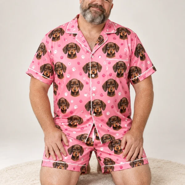 Man sitting in mens festive pajamas covered in brown dachshund puppy faces — MyDogPics