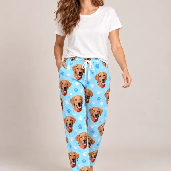 Woman wearing a pajama pants women covered in golden retriever faces on light blue paw-print fabric — MyDogPics