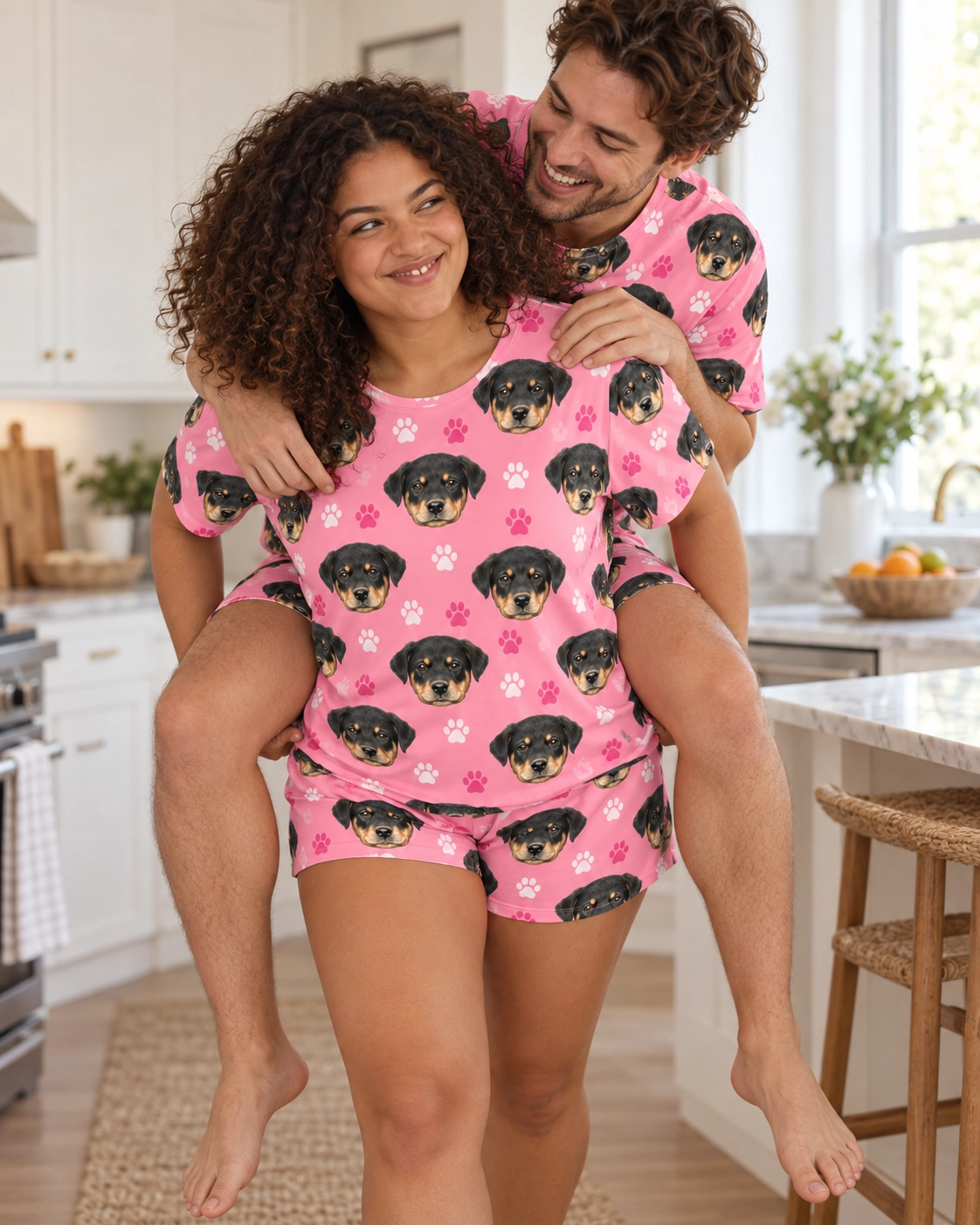 Pajama Shorts – Family, Pink Paw-Print | MyDogPics Woman and her partner in matching pajama shorts with Rottweiler puppy faces on pink paw-print fabric — MyDogPics