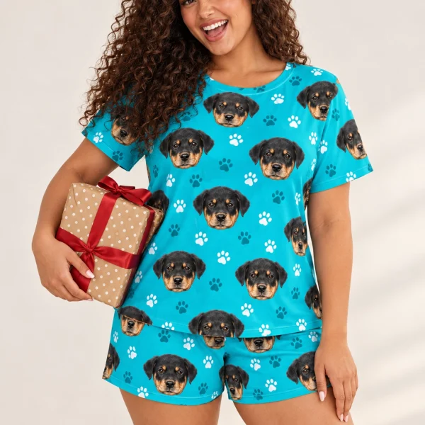 Woman wearing pajama shorts covered in Rottweiler puppy faces on teal paw-print fabric — MyDogPics