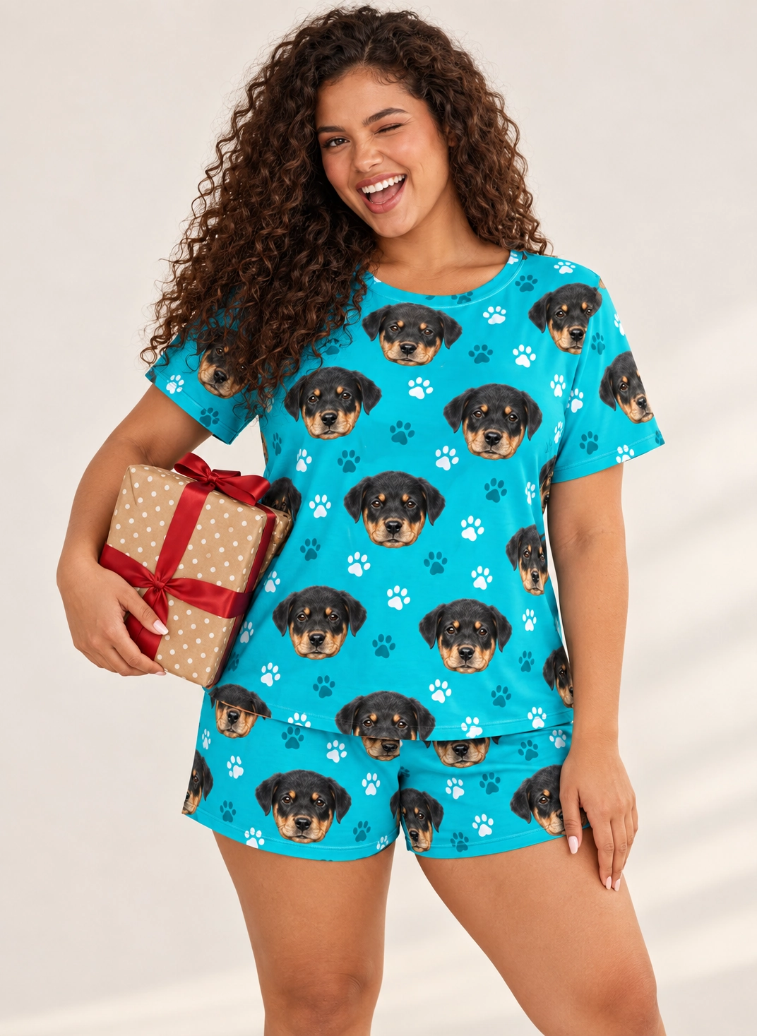 Pajama Shorts – Front View, Teal Paw-Print | MyDogPics Woman wearing pajama shorts covered in Rottweiler puppy faces on teal paw-print fabric — MyDogPics