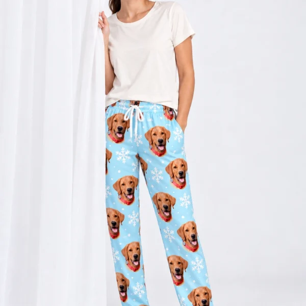 Woman wearing pink pajama pants covered in golden retriever faces on light blue snowflake fabric — MyDogPics