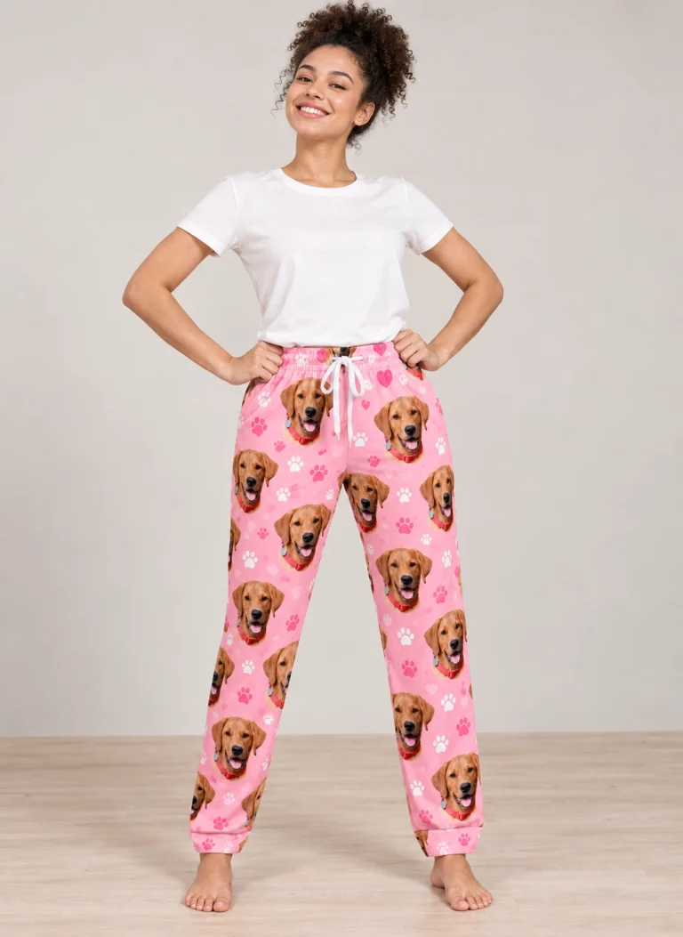 Woman wearing pink pajama pants covered in golden retriever faces on pink paw-print fabric — MyDogPics
