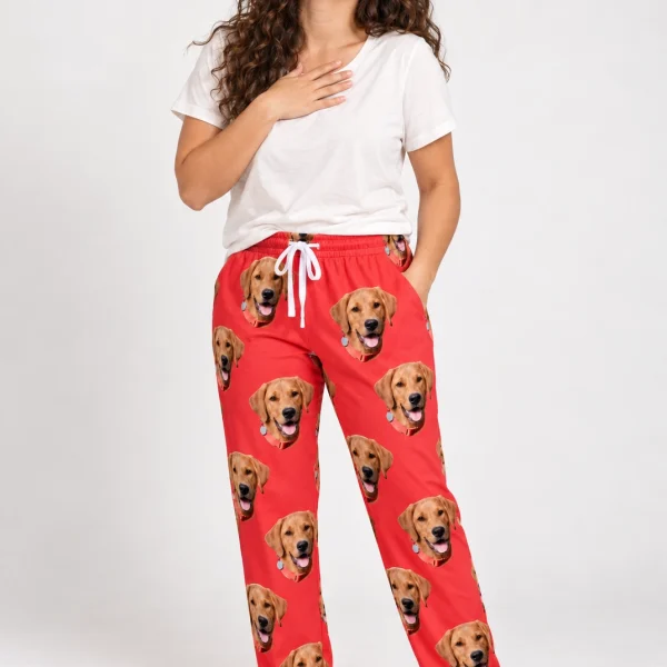 Woman wearing pink pajama pants covered in golden retriever faces on red fabric — MyDogPics