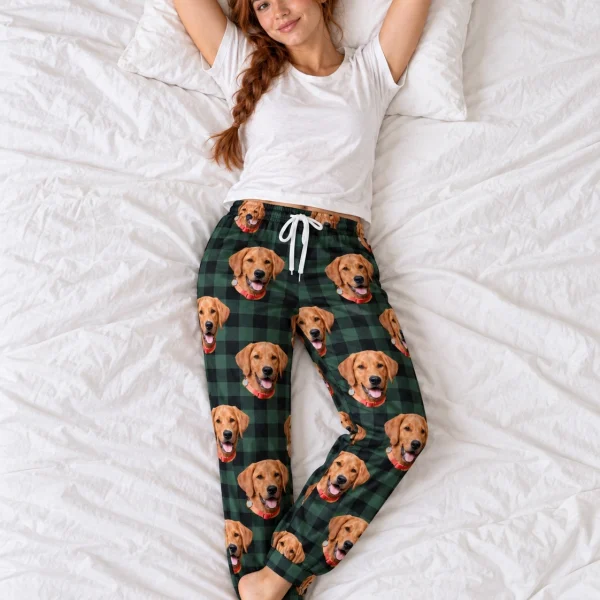 Woman posing in pink pajama pants, golden retriever faces on green plaid fabric — MyDogPics