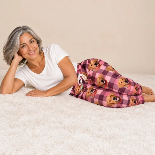 Woman posing in pink pajama pants, golden retriever faces on pink plaid fabric — MyDogPics