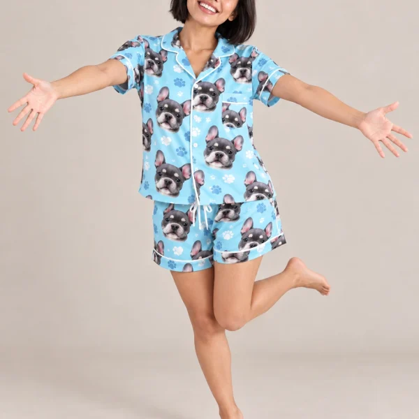 Woman posing in pink satin pajamas, grey French bulldog faces on light blue paw-print satin — MyDogPics