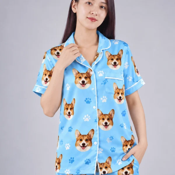 Close-up of the PJs with dogs on them print: corgi faces on sky blue satin with paw prints — MyDogPics