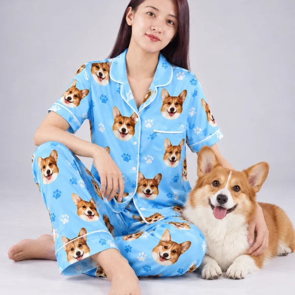Woman in PJs with dogs on them cuddling her corgi — MyDogPics