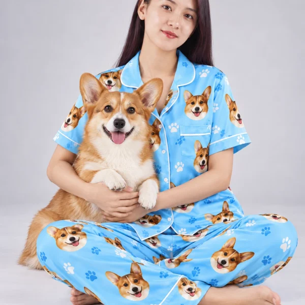 Woman in PJs with dogs on them cuddling her corgi — MyDogPics